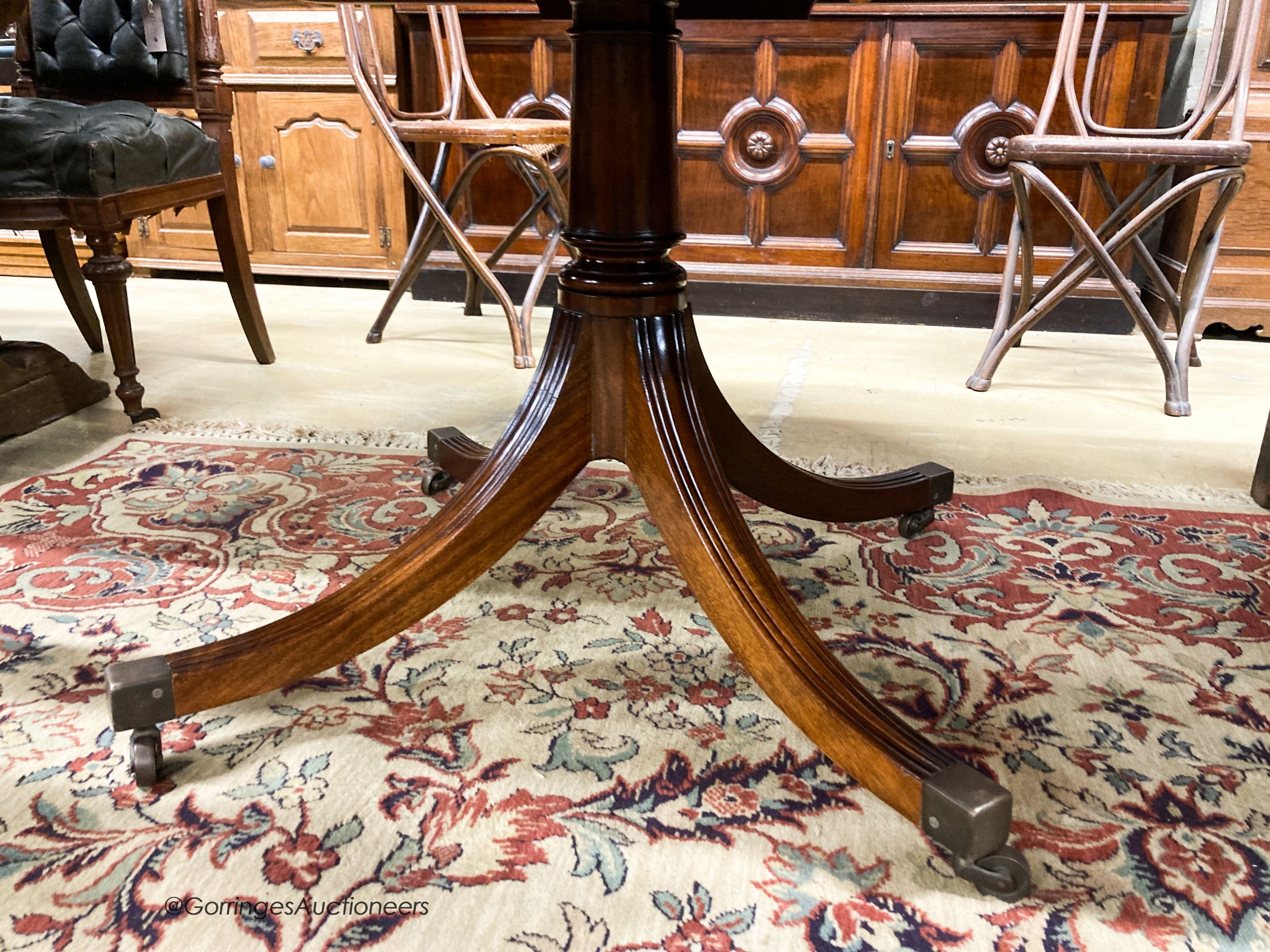 A William Tillman Georgian style mahogany and satinwood circular pedestal dining table